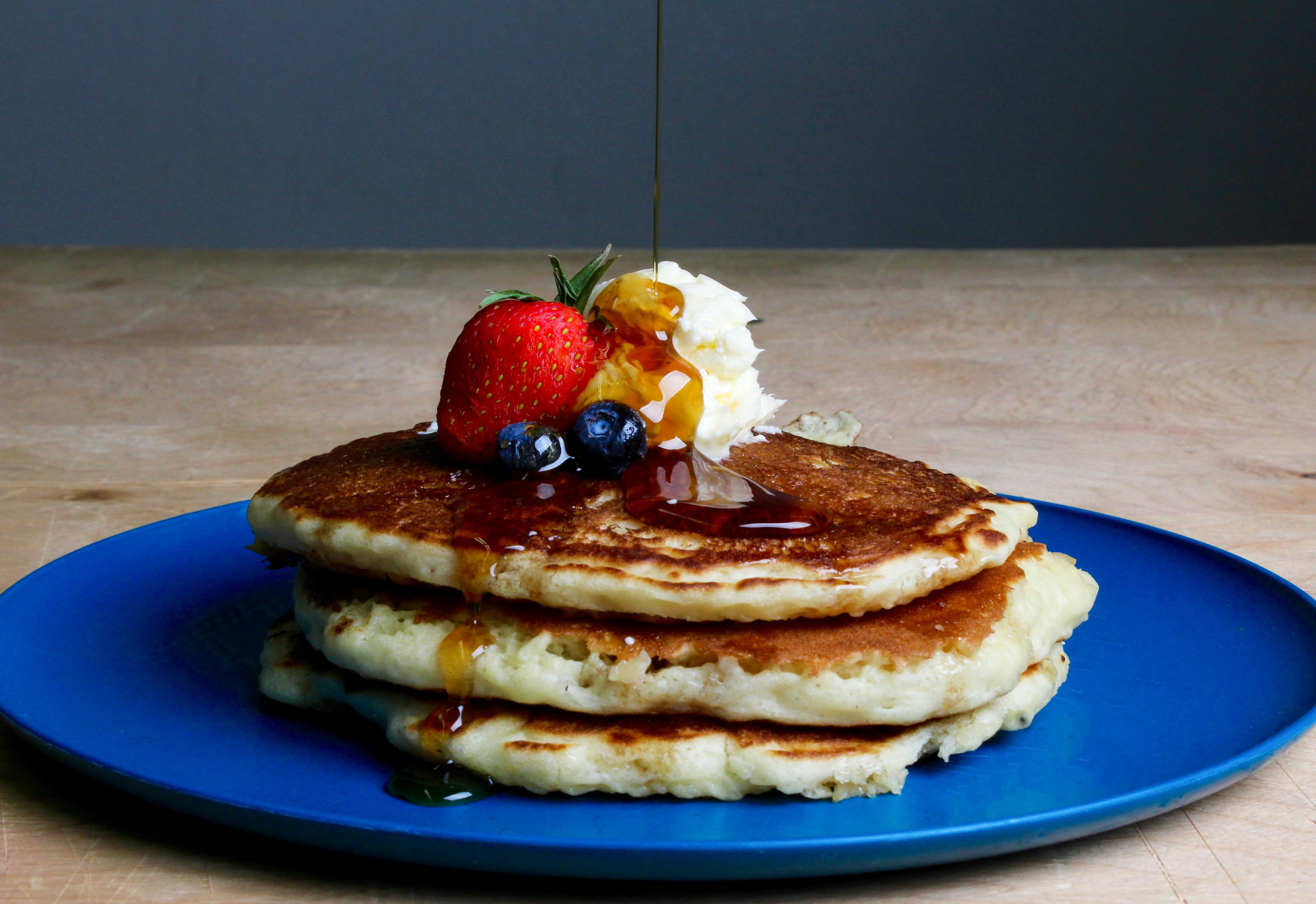 Pancakes on a blue plate, decorated with fruit.